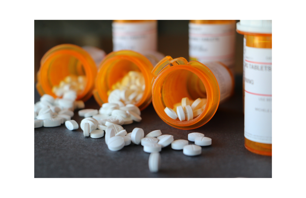 The Pill Club WARN class action. View of three prescription bottles side by side with pills spilling out. More prescriptions in the background.
