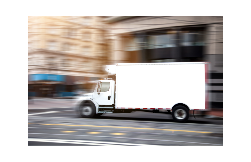 Beverage Works WARN settlement. View of a large white panel truck in focus on a city street that is shown out of focus.