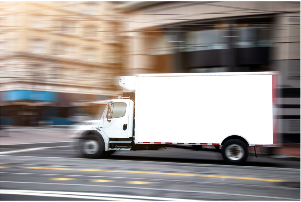 Beverage Works WARN settlement. View of a large white panel truck in focus on a city street that is shown out of focus.