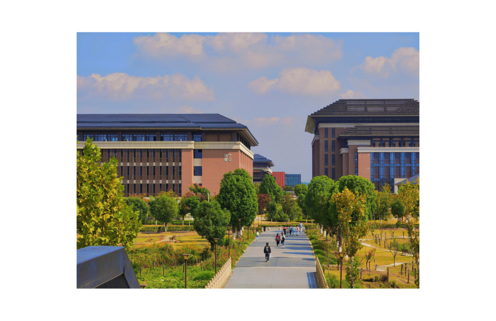 View of a large college campus. Students walk between two large brick buildings.