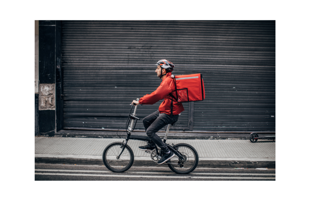 Boxed WARN class action settlement preliminarily approved. View of bicycle delivery person with food in a delivery backpack.