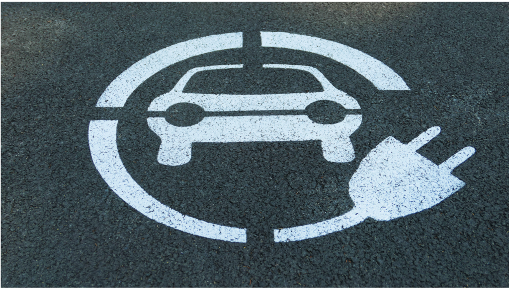Fisker WARN class action. Parking space stencil of a car with an extension cord wrapped around it, indicating electric vehicle charging.