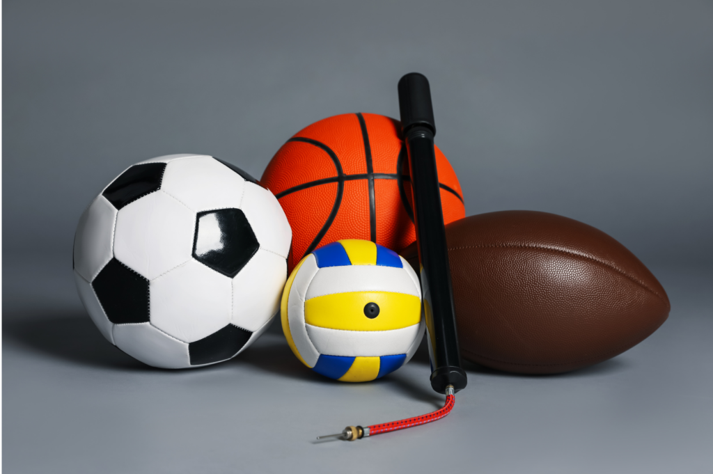 Modell's Sporting Goods WARN case. View is a tight picture of a soccer ball, basketball, volleyball, and football. A small hand air pump is leaned against the basketball.