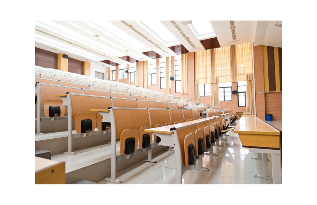 Corinthian Colleges WARN class action. View of a bright lecture room, empty of students There is tiered seating in the room with the furniture made of blonde wood with off white metal accents. The bottoms of the seats fold up when nobody is seated.
