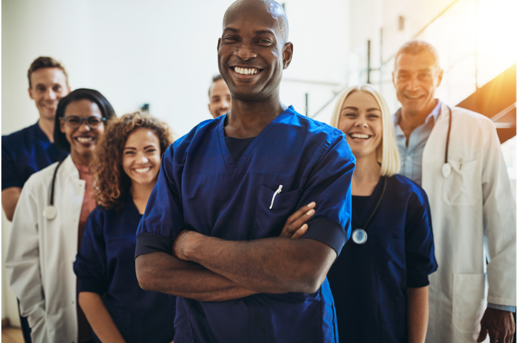 Prospect Crozer WARN class action. View of a medical staff standing in three rows. They are all wearing surgical scrubs and/or white lab coats. Most have stethoscopes over their shoulders.