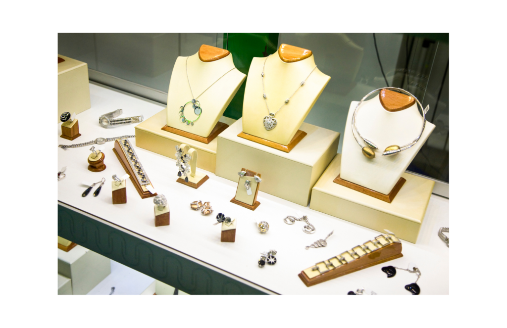 Fortunoff WARN WARN class action. View of a high end glass jewelry case. With wood and cloth displays showing necklaces, rings, and ear rings. There are also a couple of ladies watches show in the display.