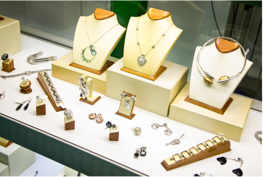 Fortunoff WARN WARN class action. View of a high end glass jewelry case. With wood and cloth displays showing necklaces, rings, and ear rings. There are also a couple of ladies watches show in the display.
