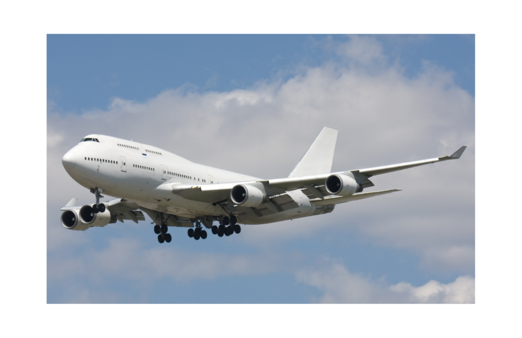 GDC Tecnics WARN class action. View of a Boeing 747 painted all in white with landing gear being either extended or retracted. The sky is a pale blue with wispy clouds in the background.