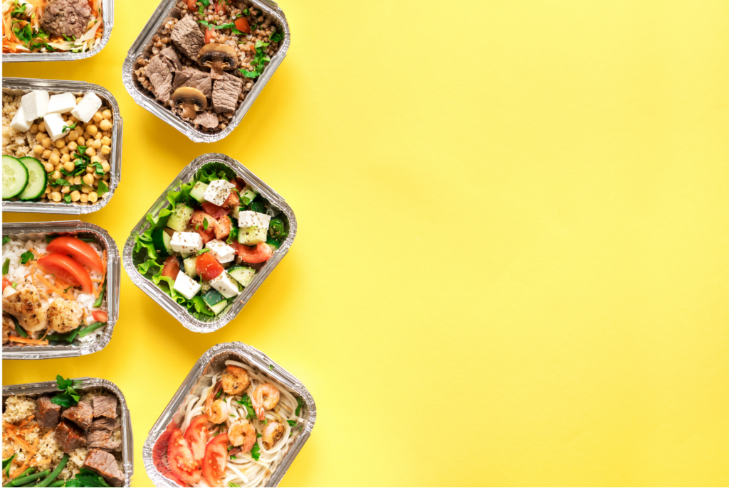 Munchery WARN class action. View of seven colorful prepared meals in single serve foil containers displayed on the left of a bright yellow background.