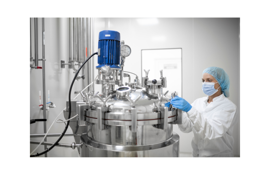 Pear Therapeutics WARN class action. View of a technician in a white jumpsuit wearing gloves, a mask, and a hairnet checking the knobs on a large medical compressor of some sort. The rooms seems almost sterile with white walls and pipes for hot and cold water extending from one wall.