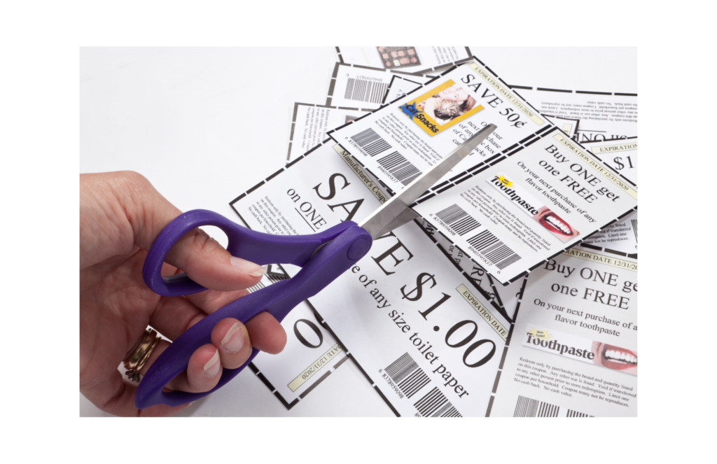 Pennysaver WARN class action. View of a women's left hand using purple handled scissors to trim coupons. There is a small pile of already trimmed coupons. The coupons are generally white with pictures. This is all shown against a white background.